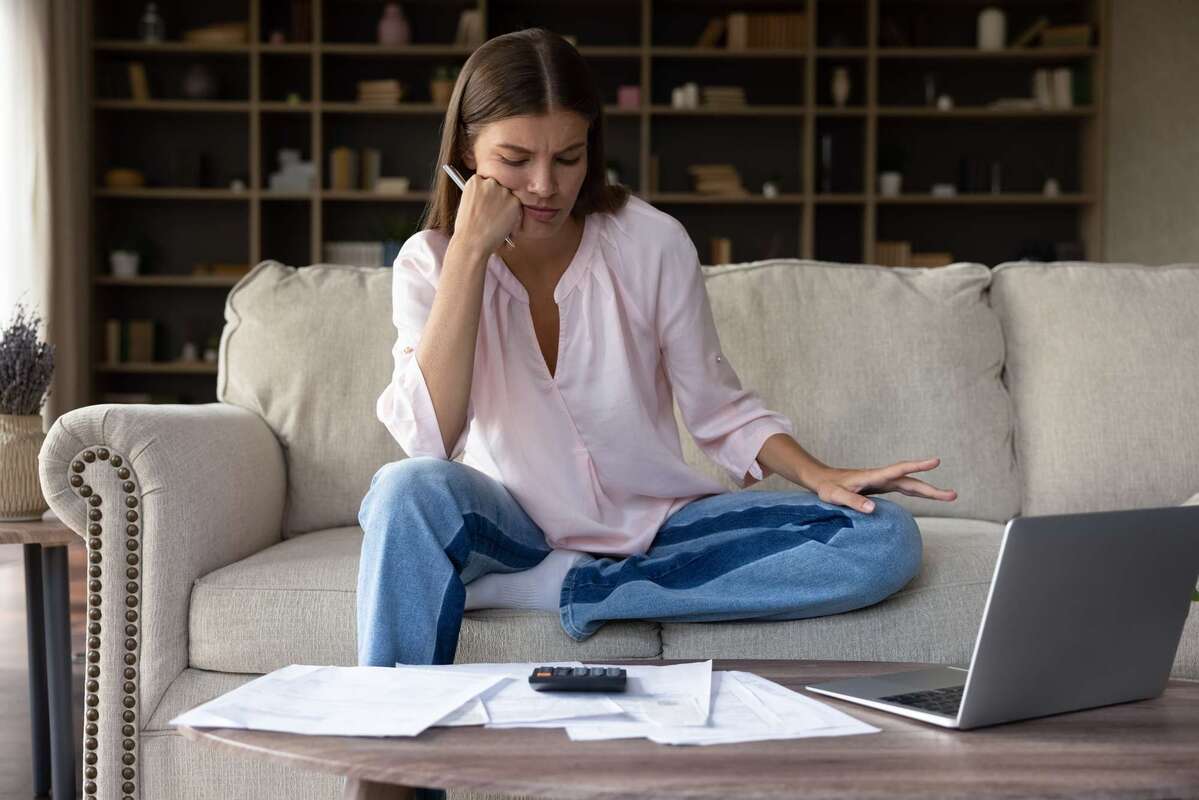 Concerned frustrated millennial homeowner girl looking at bills for payments (R) (S)