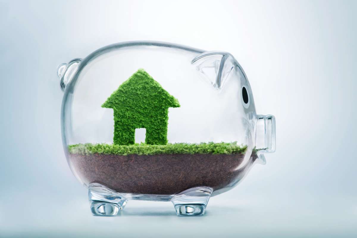 Saving to buy a house or home savings concept with grass growing in shape of house